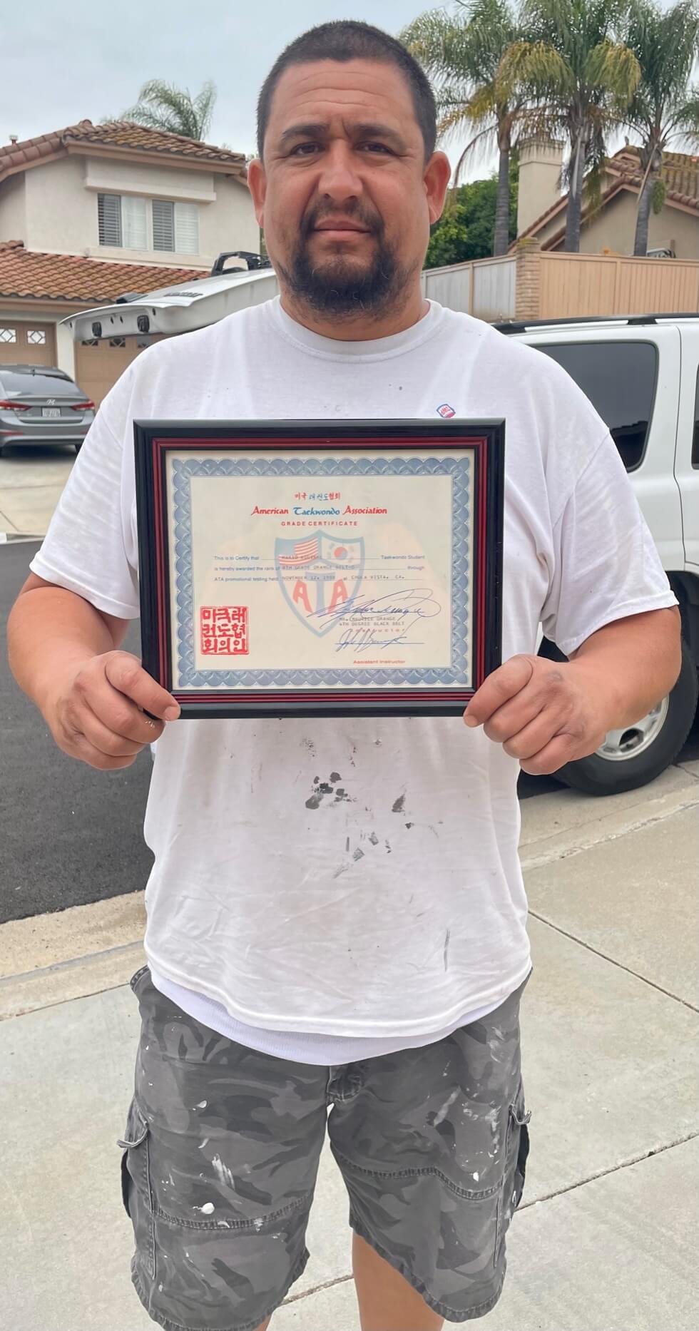 Mario holding his Certificate